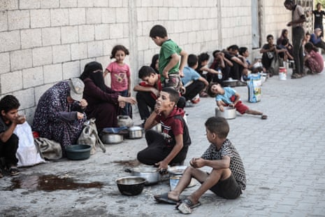 A large number of Palestinians, including children, gather in order to get food, in Nuseirat refugee camp, central Gaza, on Wednesday.