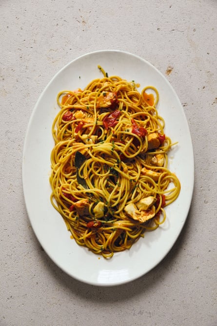 Spaghetti with fish and saffron on a large white oval dish