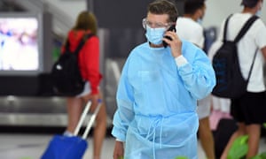 Un hombre con equipo de protección personal en un área de recolección de equipaje en el aeropuerto de Tullamarine en Melbourne el viernes.