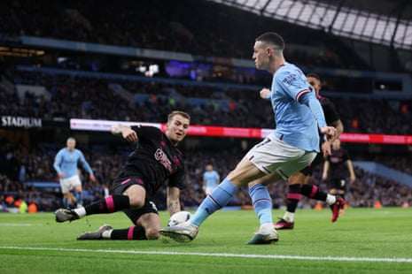 Jordan Beyer of Burnley slides in to challenge Phil Foden of Manchester City.