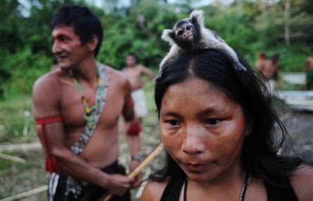 A Munduruku Indian woman carries a monkey on her head while on a search for illegal goldmines in western Para state, Brazil.