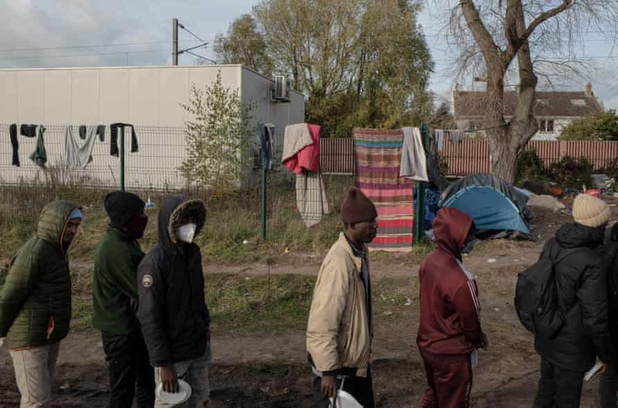 Des réfugiés font la queue pour recevoir de la nourriture distribuée par des ONG locales à Calais, en France.