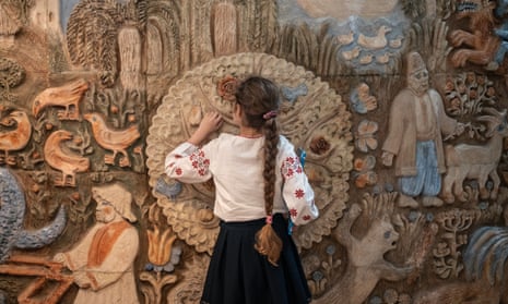 A child explores the ceramic frieze depicting Ukrainian fairytales by Ukrainian artist Olga Rapay-Markish in the National Library for Children in Kyiv.