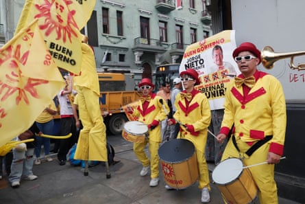A band with drums and brass instruments and dressed in yellow play in support of Jorge Nieto