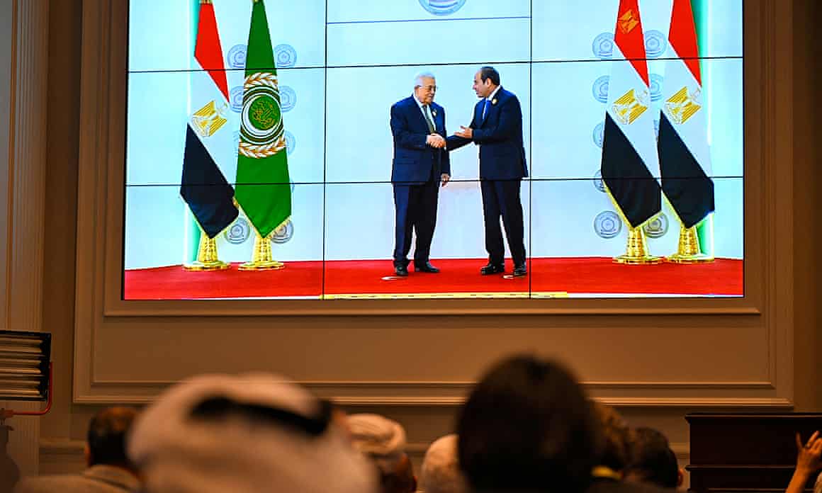 People watch on a big screen as Egypt’s president, Abdel Fattah al-Sisi (right) welcomes the Palestinian president, Mahmoud Abbas, before the Arab League summit in Cairo.