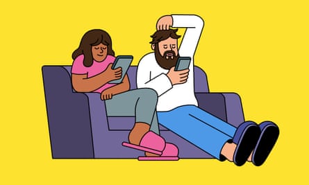 Couple sitting on a sofa both engaged on their phones