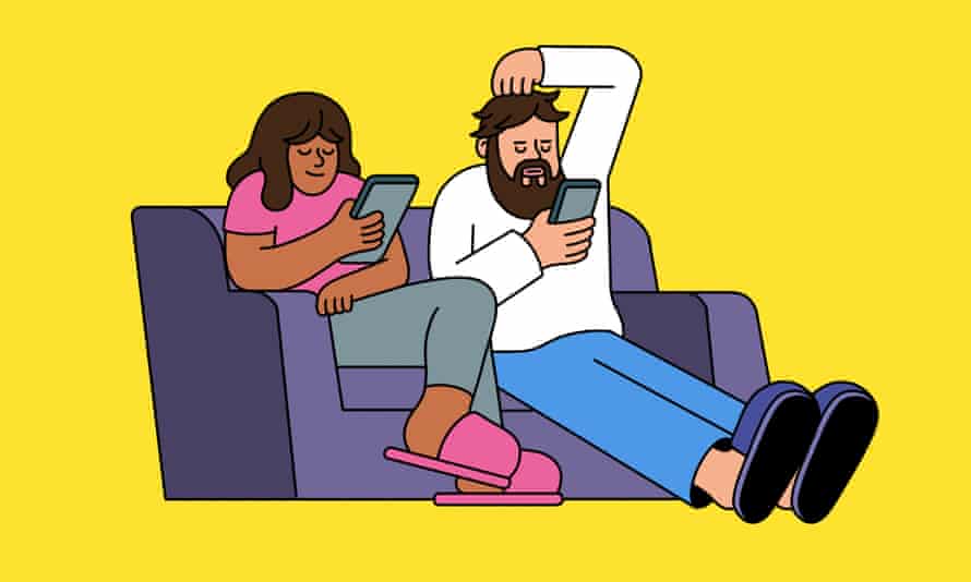 Couple sitting on a sofa both engaged on their phones