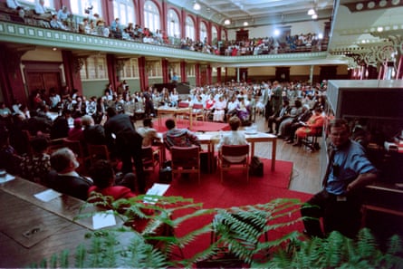 People sitting in rows in the main space and balcony of a large room
