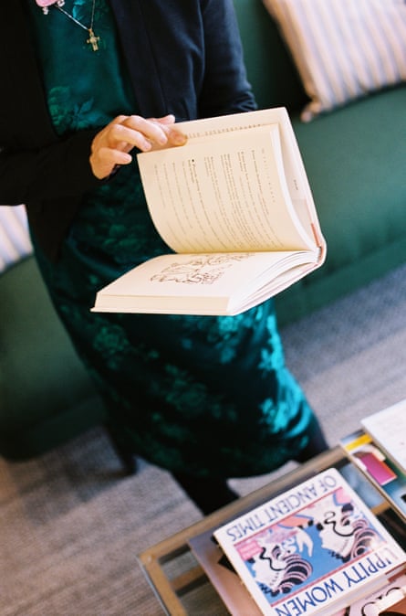 a woman holding a makeshift candle and a book