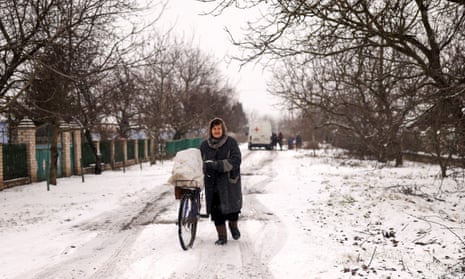 A woman transports food that volunteers have given her on her bicycle near Kherson.
