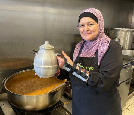 A woman in a headscarf posing with a traditional Egyptian pot, and a large saucepan of ful medames.