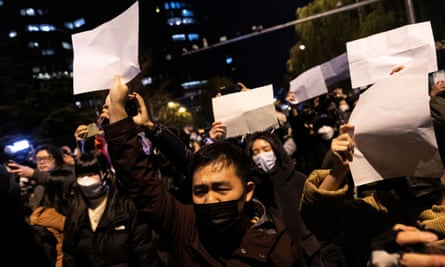 In Beijing, people held white sheets of paper in protest over Covid restrictions, after a vigil for the victims of a fire in Urumqi.