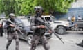 Armed security personnel in full kit in road on patrol