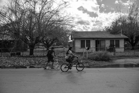 A girl on a bike and a boy on a scooter outdoors