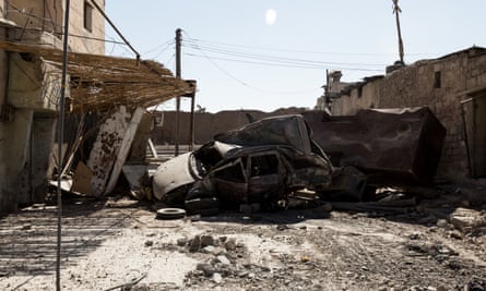 Burnt-out cars used as a temporary road blockade near a Syrian Democratic Forces base near the frontline.