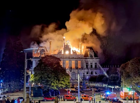 Onlookers watch as a fire burns and destroys part of the City Hall in Limoges.
