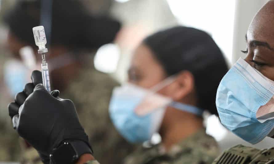 US navy personnel prepare doses of the Pfizer vaccine for administration