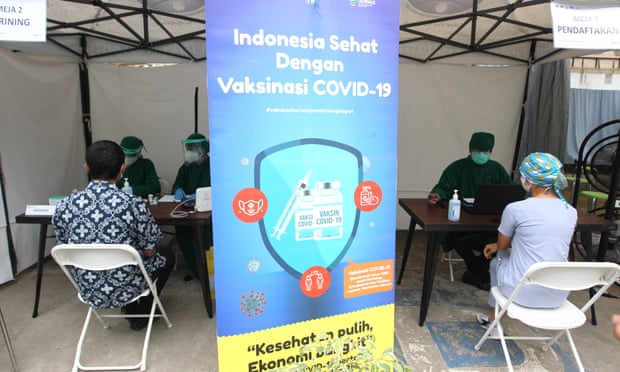 Health workers wait to be vaccinated at a facility in Jakarta