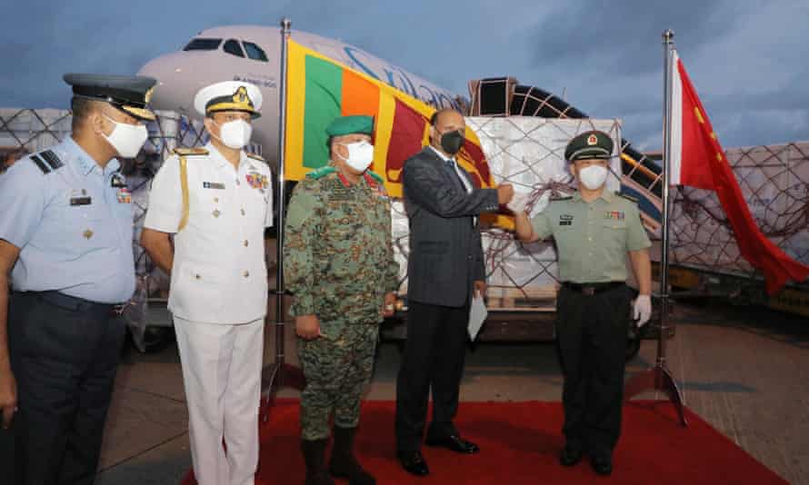 Wan Dong (right), Defense Attaché at the Chinese Embassy in Sri Lanka, and Kamal Gunaratne (second from right), Secretary General of Defense of Sri Lanka, bang their fists when handing over a prize of Sinopharm vaccine.