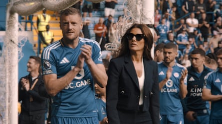 Jamie Vardy walks around the pitch with Rebekah Vardy