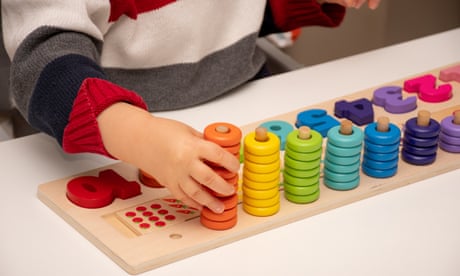 Young child playing with stacking toy