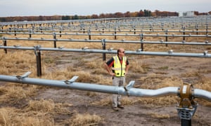 Farmer Norm Welker stands amid the construction of solar panels on his land in North Bend Township, Indiana.