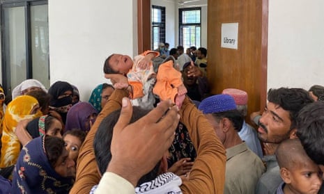 baby carried aloft at camp in warah, sindh province, pakistran
