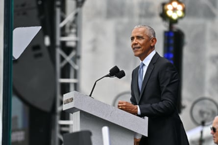Barack Obama in suit and tie speaking at an outdoor lectern.