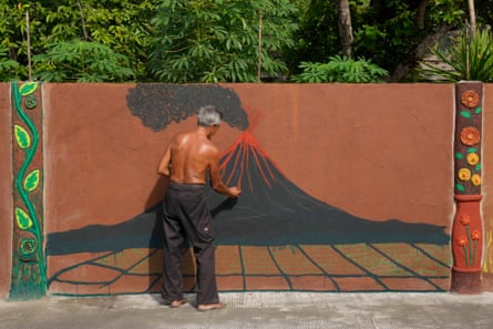 A local artist paints a picture of the erupting Mayon volcano