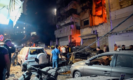 People gather in front of a damaged building