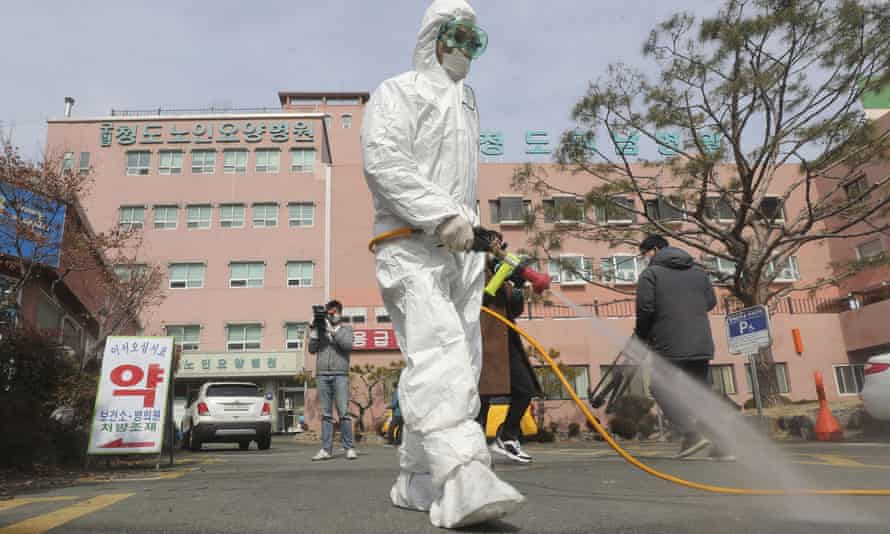 A worker in protective gears sprays disinfectant outside Daenam Hospital in Cheongdo, South Korea, on Friday.