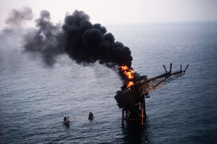 Flames shoot up from the teetering oil rig