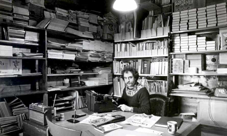 Stuart Christie with a moustache in 1980 at an ‘office’ crowded with books