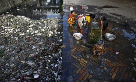 A boy takes bath from a water tap near a polluted water channel in Kolkata, India.