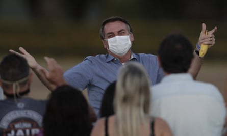 President Jair Bolsonaro greets supporters outside his official residence the Alvorada Palace, in Brasília, on 24, after he tested positive for coronavirus earlier that month.