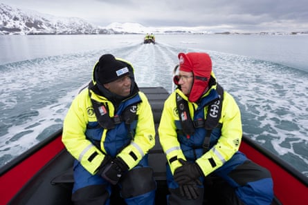 Two men in a boat amid glaciers