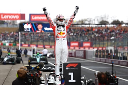 Max Verstappen celebrates winning the Japanese Grand Prix at Suzuka by standing on his Red Bull car with arms aloft