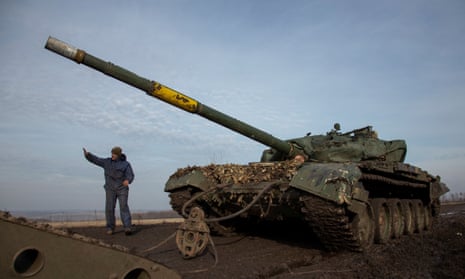 A Ukrainian soldier gestures while pulling a broken tank to a truck near the frontline town of Bakhmut.
