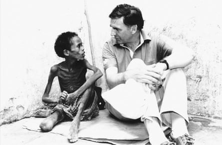 Tony Worthington sitting next to a severely malnourished boy.