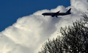 A passenger aircraft makes its landing approach towards Heathrow airport above Richmond Park