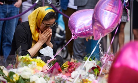 woman with flowers in Manchester to remember those killed in the Manchester Arena attack