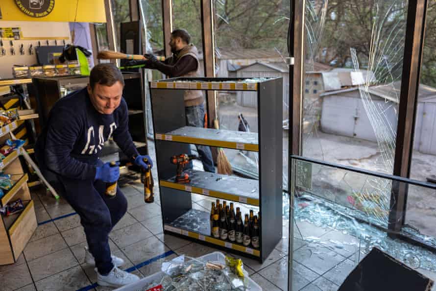 Shop owners salvage stock from a beer and wine store near the site of the missile strike.
