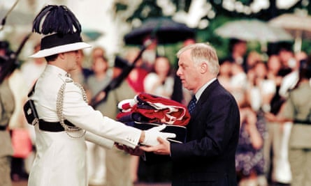 Chris Patten, the 28th and last governor of colonial Hong Kong, receives the union jack flag after it was lowered for the last time at Government House in 1997