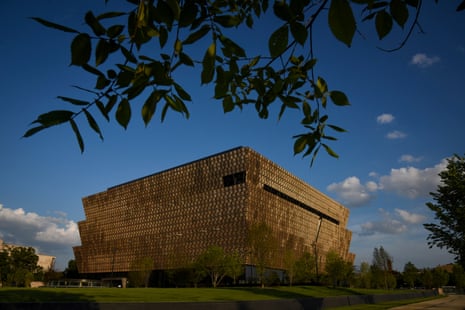 exterior of a bronze-colored building surrounded by grass and trees