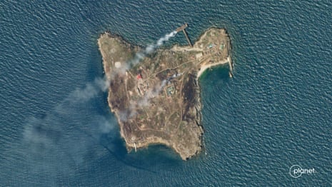 A satellite image shows smoke rising from Snake Island, off the coast of Ukraine.