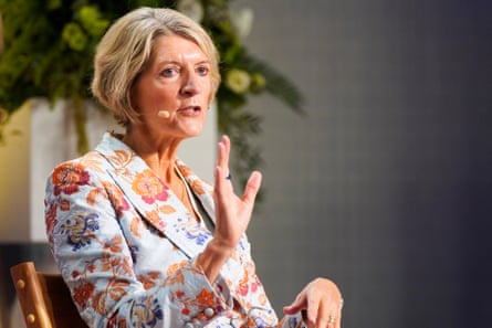 a woman speaks into a microphone while seated