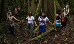 A female widow holds hands with indigenous people encircling a tree