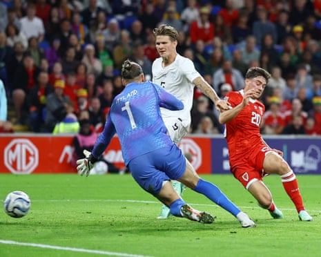 Wales’ Daniel James sticks the ball past Norway’s keeper Orjan Nyland to level the score.