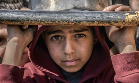 Child in a hoodie with bowl on head and grubby face