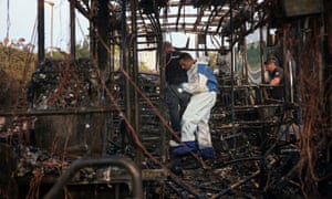 A police forensics officer examines the wreckage of a number 12 Egged bus gutted during a suspected explosion in Jerusalem on Monday.